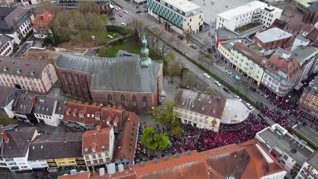 Aerial view, sliding sideway by Altstadt Main street in Kaiserslautern Germany on a Saturday while FCK Football Club Fans celebrating ther victory (Win ) cheering, drinking beer at street intersection