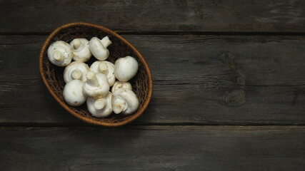 Fresh champignons uncooked on a wooden table