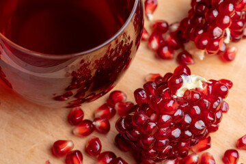 A small ripe red pomegranate is lying on the table