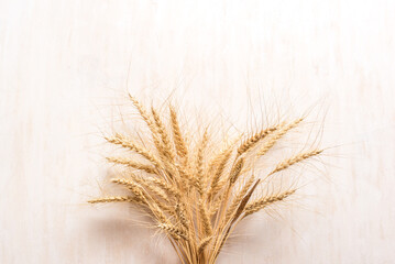 Wheat ears on white wooden background