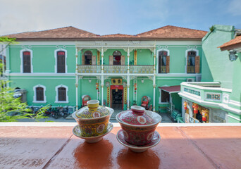 chinese ceramic tea cups with peranakan house background.