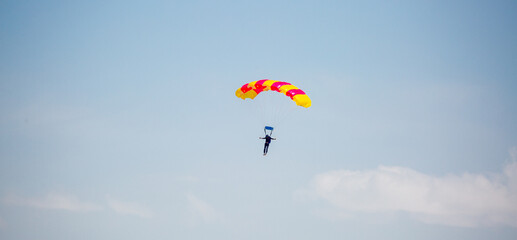 Skydiving. Flying parachutists against the background of the blue sky and mountains. Extreme sport and entertainment.