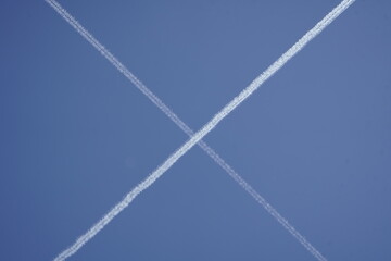 Contrails from two crossing passenger planes over Hanover, Germany.