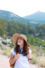 young girl in a straw hat and a backpack.