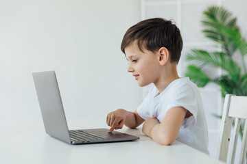education online online games classes a child sitting at a laptop with a finger at school