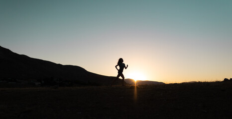 girl runs at sunset in the mountains.