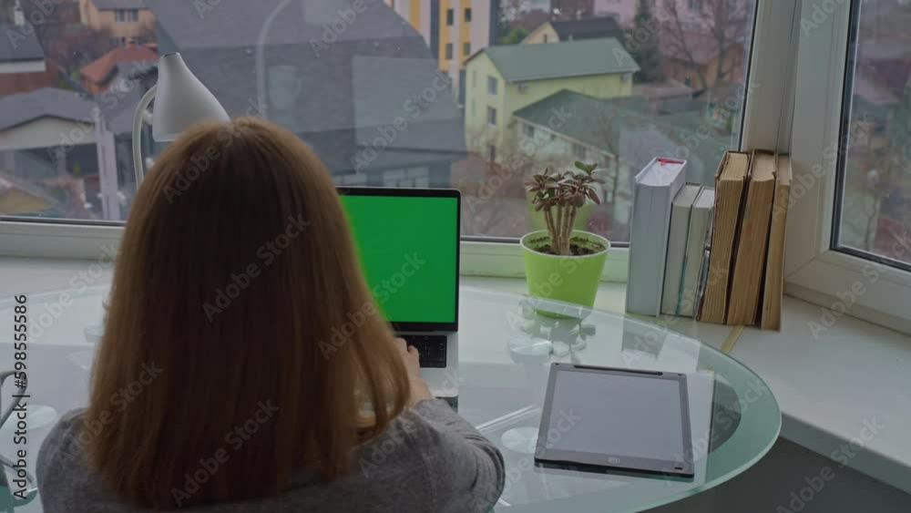 Aufkleber businesswoman sitting at workplace typing on keyboard laptop with green display workspace in apartme