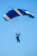 Skydiving. Flying parachutists against the background of the blue sky and mountains. Extreme sport and entertainment.