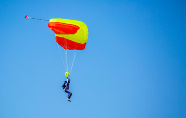Skydiving. Flying parachutists against the background of the blue sky and mountains. Extreme sport and entertainment.