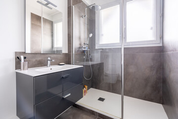 Home bathroom, bright new bathroom interior with tiled glass shower, vanity cabinet, interior designed white and with black tiles