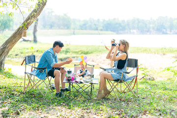 Fototapeta premium Family enjoying a camping holiday in the countryside ,Camping, travel, tourism, hiking and people. Concept - Happy family with backpacks and thermos at camp.