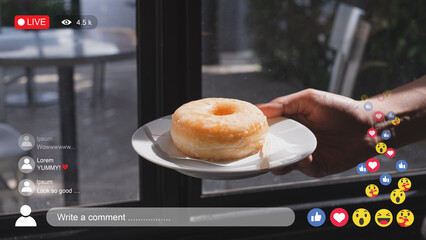 An influencer, blogger or vlogger is showing a piece of donut to camera while live streaming....