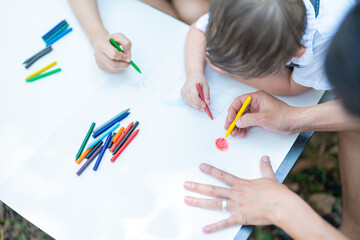 Happy harmonious Asian family park outdoors concept. Mother father and son have activities teaching and learning together on holidays.