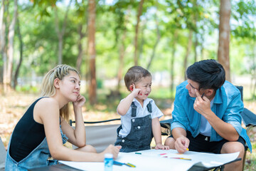 Happy harmonious Asian family park outdoors concept. Mother father and son have activities teaching and learning together on holidays.