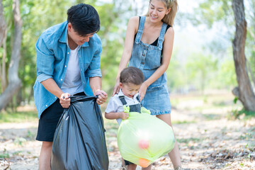 Asian family picking up trash in the forest. Litter cleanup activities. Environment protection....