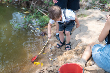 Family activity to scoop fish in a natural stream in the countryside.