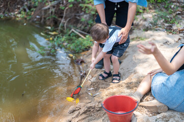 Family activity to scoop fish in a natural stream in the countryside.