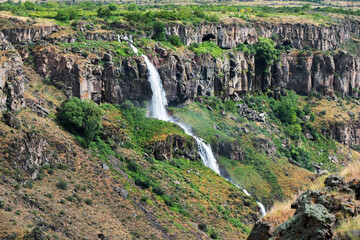 The waterfall descends between the rocks. in Armenia.
