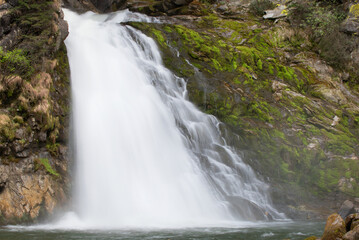 Fototapeta na wymiar lunga esposizione acqua di una cascata delle dolomiti, una splendida cascata con del bel muschio verde di fianco, la bellezza dei panorami delle dolomiti.