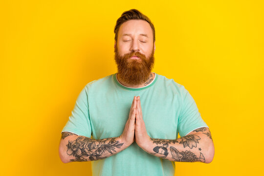 Portrait of attractive calm man eyes closed wear stylish green clothes two arm together pray for peace isolated on yellow color background Generative AI
