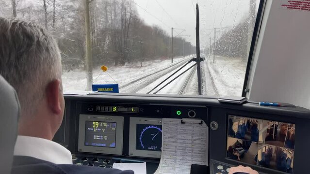 Modern train driver's cabin during movement by rail. Winter.