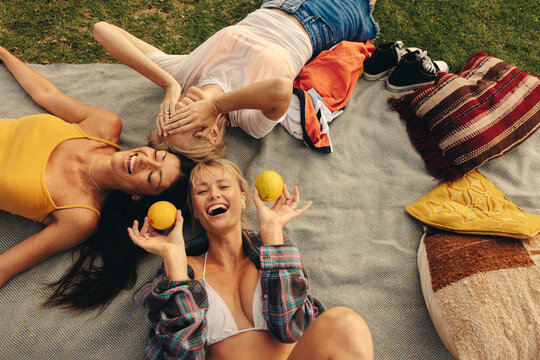 Friends lying in a park together, laughing and having fun together