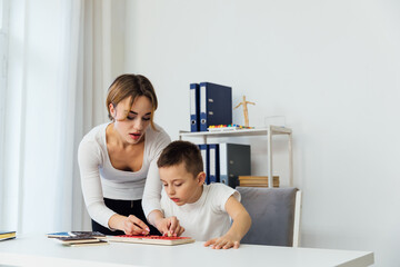 Obraz premium the work of a child psychologist with a child in the office of educational games