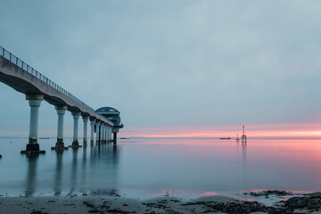 Fototapeta premium A beautiful pier in the calm sea at sunrise