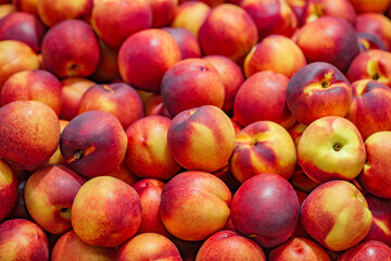 Nectarines, peaches, whole, in bulk, on supermarket, selective focus