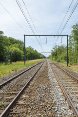 Fototapeta na wymiar out of sity railway tracks electric wires blue sky perspective landscape blue sky