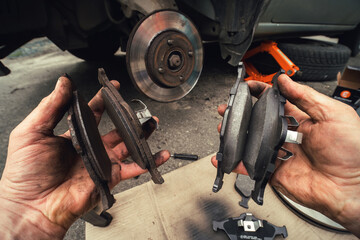 Disk brake and car service concept - Vehicle brake pad replacement service by hand of mechanic man...