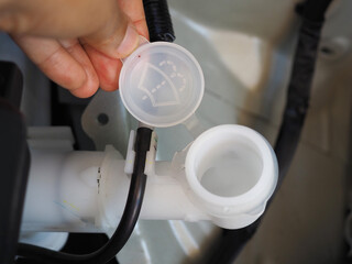 Hand open liquid cap in car engine installed front under the hood near automobile engine.