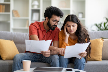 Stressed Young Indian Couple Checking Financial Papers At Home Generative AI