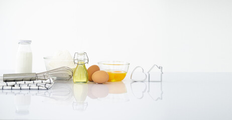 Dessert ingredients and utensils on white reflect table background . Front view. Copy space. egg,...
