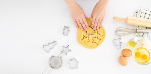 Woman preparing gingerbread cookies on white table at kitchen . Female hands cutting ginger dough with cutter to making cookies for winter holidays.top view.copy space. Banner