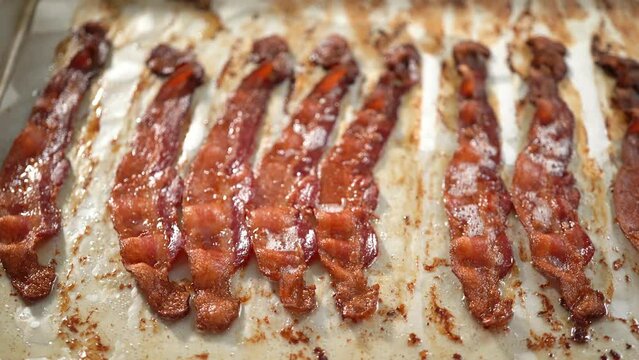 Step by step. Cooked bacon strips on a baking sheet with white parchment paper. Generative AI