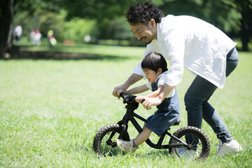 自転車の練習をする親子　新緑の公園でレジャー　ママと男の子　コピースペース左