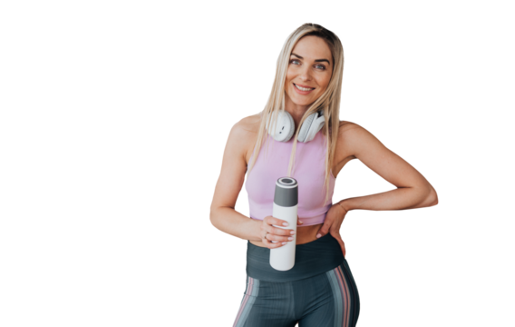 Cheerful blonde caucasian young girl in sportswear holds bottle of water looks at camera toothy smiles stands over transparent background. Healthy lifestyle, sporty women. woman at break of exercise