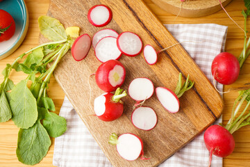 Fototapeta na wymiar Fresh red radish slices on a wooden background, top view.