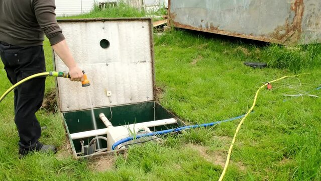 The man is cleaning septic. Maintenance autonomous sewerage service. Processing station biological water purification. Local household sewerage system. Environmental protection. Water protection zone.