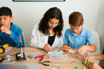 Smart teen students using an electronic circuit in class