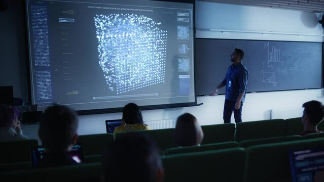 Young University Professor Explaining the Importance of Artificial Intelligence to a Group of Diverse Multiethnic Students in a Dark Auditorium. Teacher Showing Neural Network on Two Big Screens