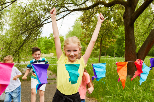 Happy girl winning race competition in park on vacation