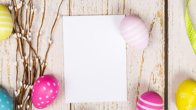 greeting card with text happy easter. multicolored easter eggs on wooden background