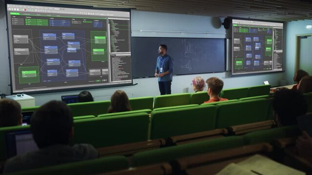 Young Male Teacher Giving a Web Development Masterclass to Diverse Multiethnic Group of Female and Male Students in a Modern College Room. Projecting Slideshow with Initial Programming Project Plan