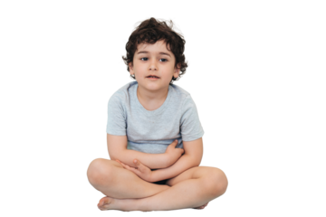Little curly caucasian boy sitting against transparent background waits for doctor for examination. Handsome American toddler needs medical help. Medicine, healthcare, childhood.