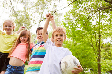 Multiracial boys and girls cheering after winning game