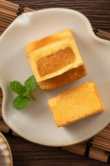Delicious pineapple cake pastry in a plate on wooden table background with tea.