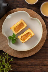 Delicious pineapple cake pastry in a plate on wooden table background with tea.