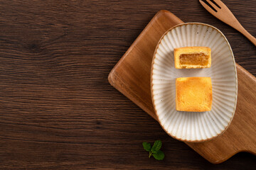 Fototapeta na wymiar Delicious pineapple cake pastry in a plate on wooden table background with tea.